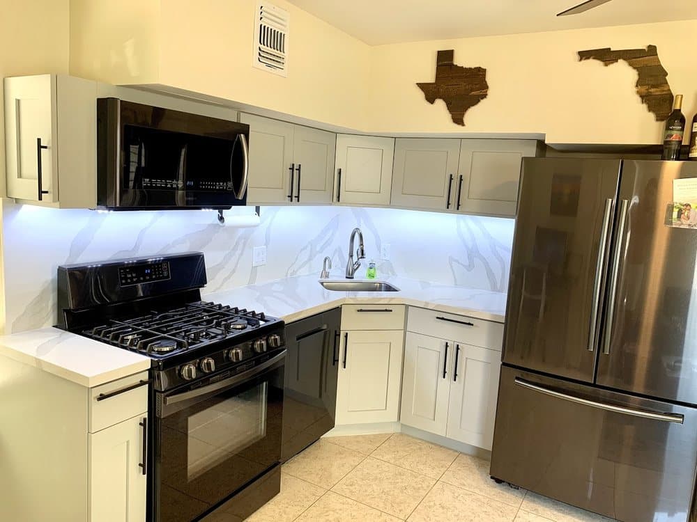 Marble-look quartz countertop and full-height backsplash with gray cabinets